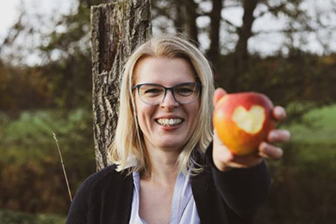 Frau hält Apfel in der Hand